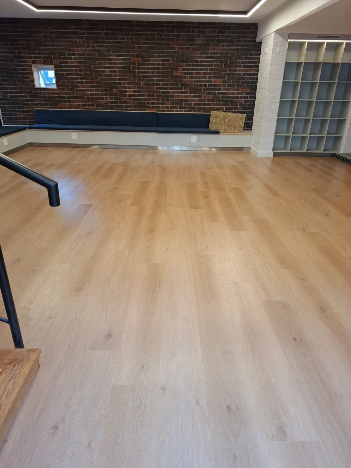 Floornet Roccoco Heavy vinyl in Hazelnut across a common room with a face-brick feature wall