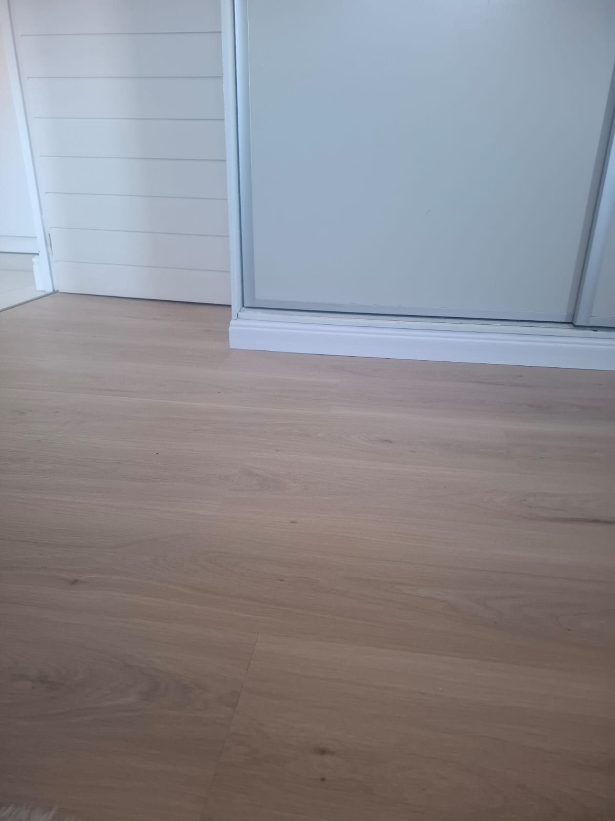 Aspen SPC Italian Oak running up to a built-in wardrobe with crisp skirting